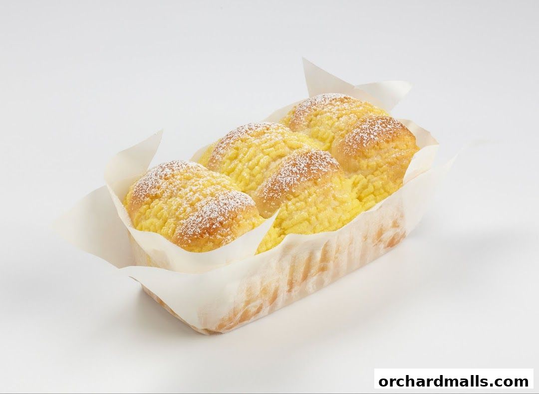 A loaf of bread with a creamy yellow filling and powdered sugar.