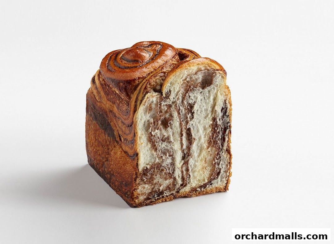 A close-up shot of a marbled chocolate swirl bread loaf on a white background.