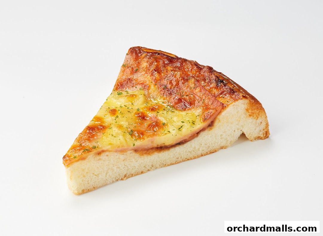 A slice of savory bread with cheese and ham, sprinkled with herbs.
