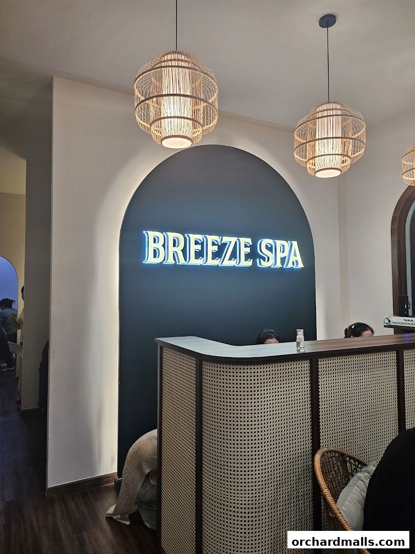 The reception area of Breeze Spa features a neon sign and a stylish reception desk.