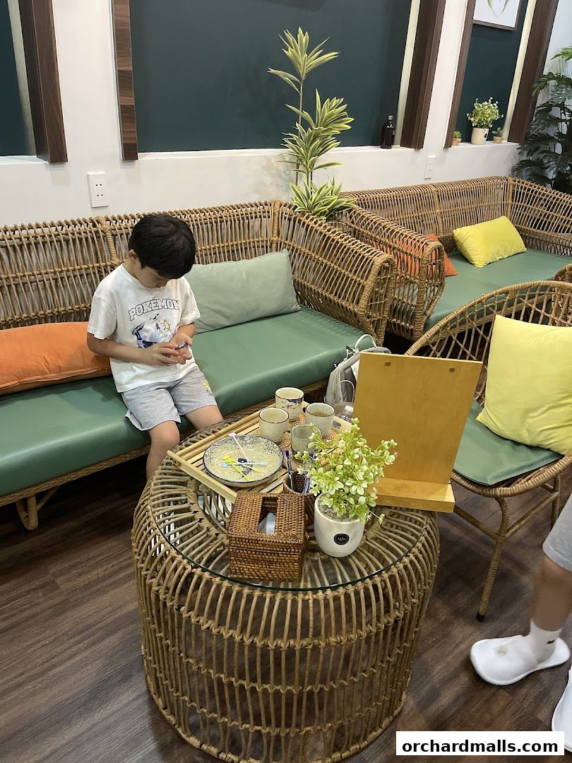 A young boy sits on a sofa in a spa waiting area with a coffee table.