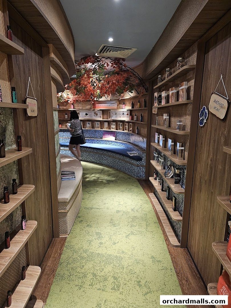 Interior of a shop with shelves displaying products and a curved seating area.
