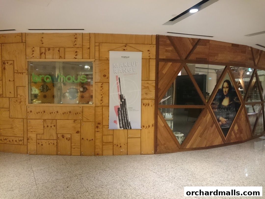 The exterior of Browhaus Wheelock shop with wooden paneling and a makeup range poster.