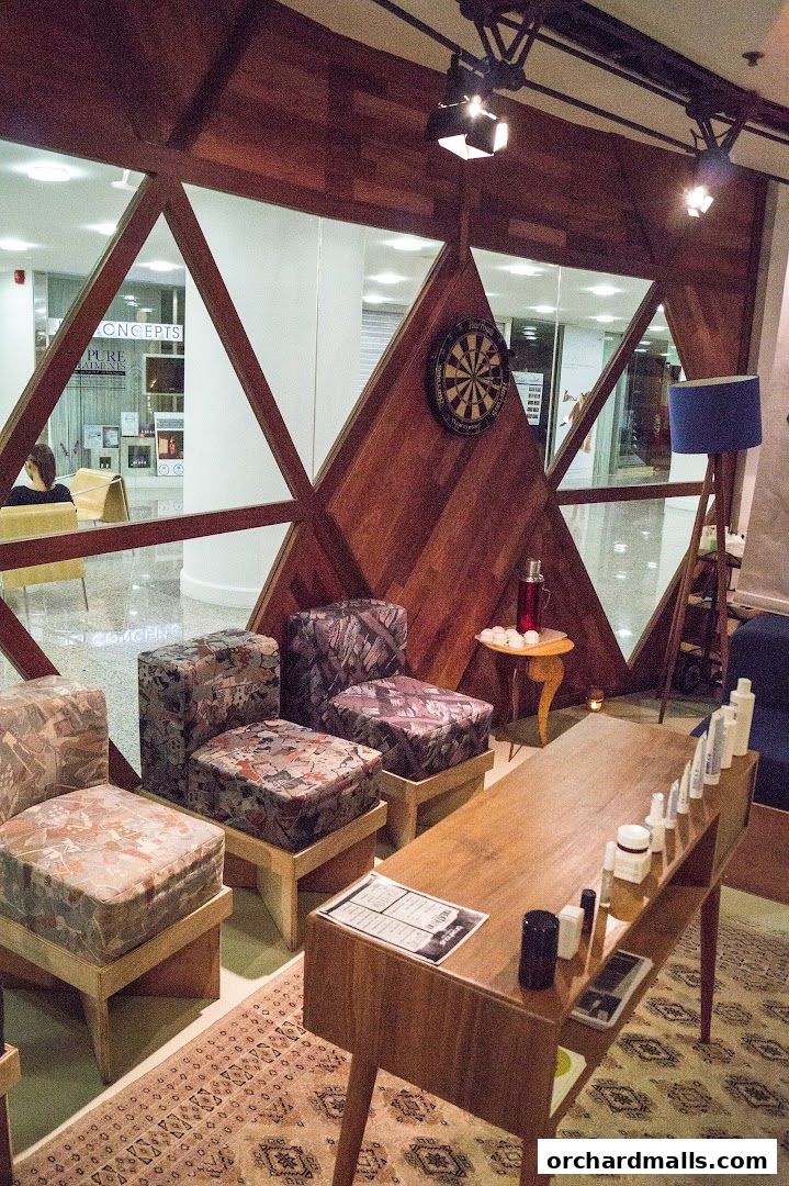 Interior of a shop with seating, a display table with products, and decorative elements.