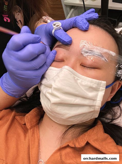 A close-up of a client receiving eyebrow microblading treatment at Browstation Beaute.
