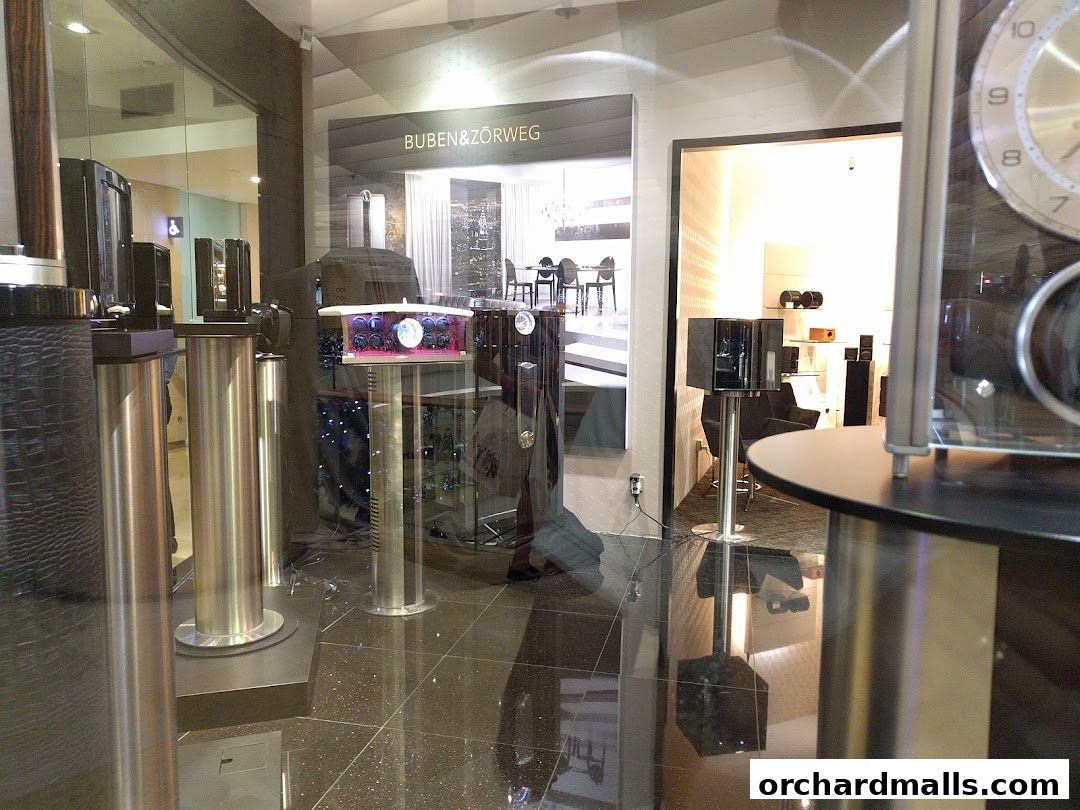 Interior view of a luxury watch and accessory store with display cases and products.