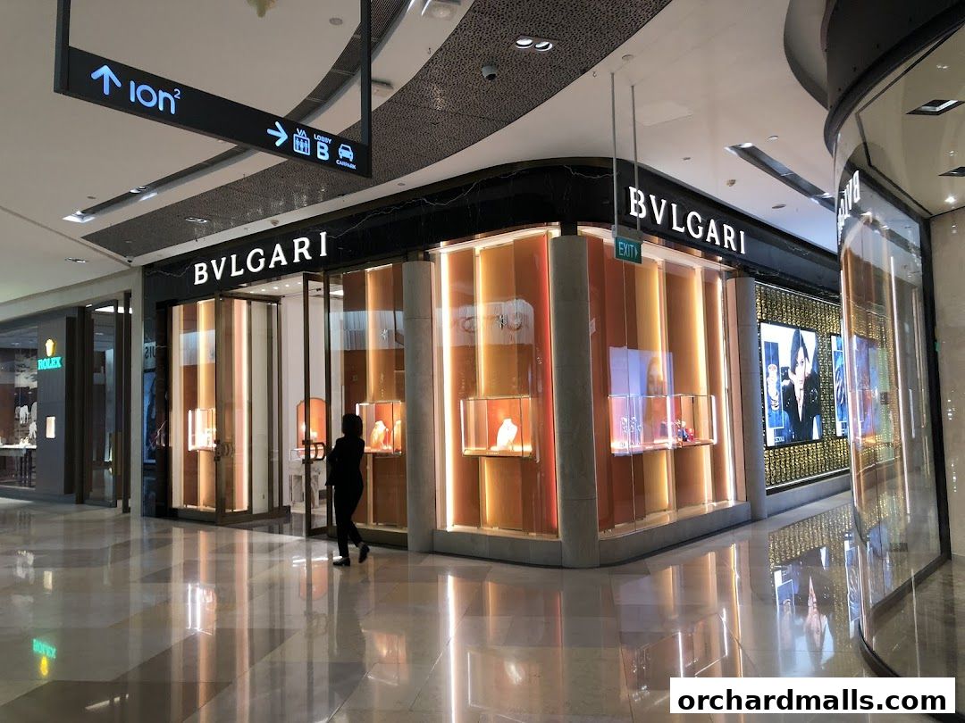 The BVLGARI store at ION Orchard features a modern facade with illuminated display cases showcasing jewelry.