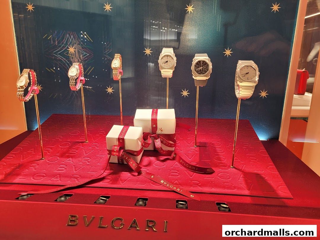 A BVLGARI shop window display featuring several luxury watches and gift boxes.