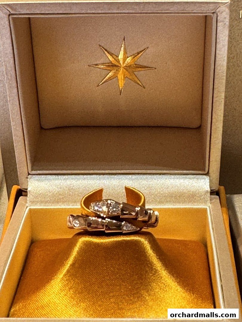 A luxurious gold ring with diamonds displayed in an open jewelry box.