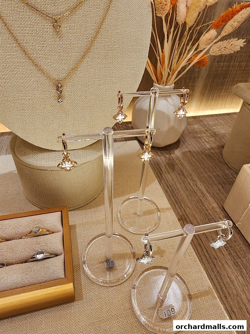 A display of elegant gold necklaces and earrings, with rings in a wooden box.