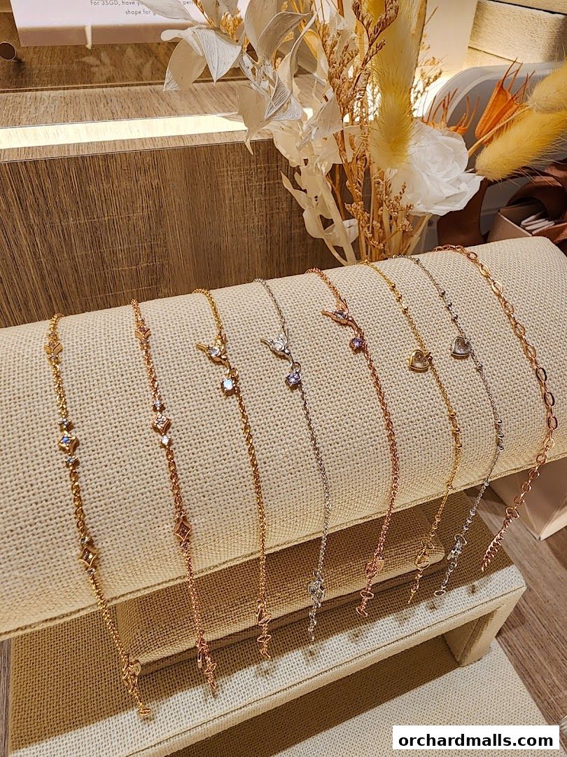A display of delicate gold, rose gold, and silver bracelets with charms.