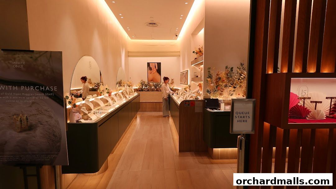 Interior view of a modern jewelry store with display cases and a staff member.