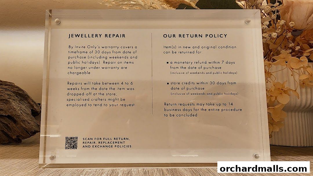 A sign detailing jewellery repair and return policies for By Invite Only Jewellery.