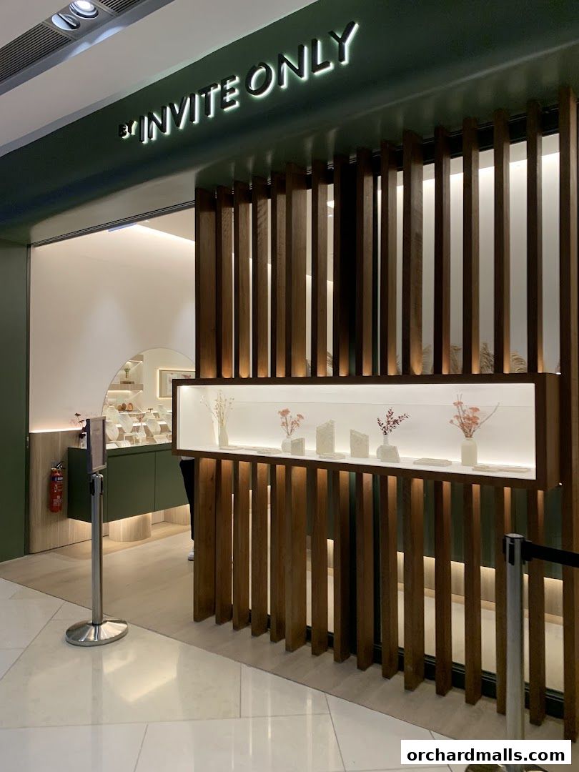 The entrance to By Invite Only Jewellery, featuring a modern design with wooden slats and illuminated displays.