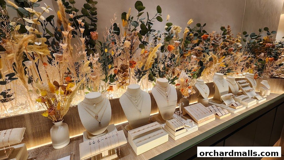 A jewelry display featuring necklaces and bracelets on mannequins and stands, with floral decor.