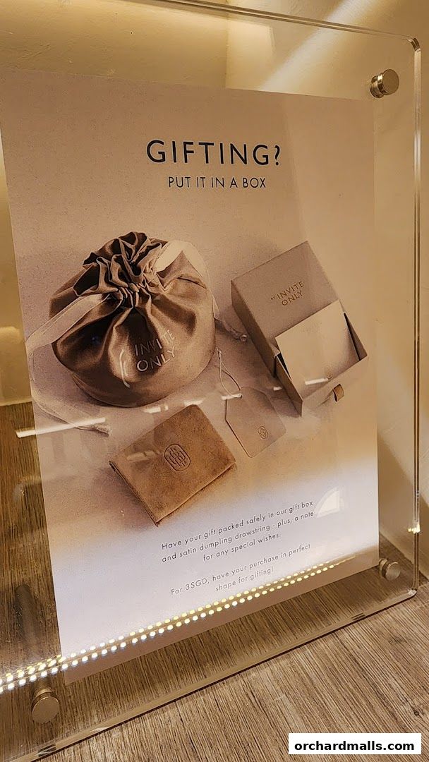 A sign advertising gift packaging services for jewelry from By Invite Only.