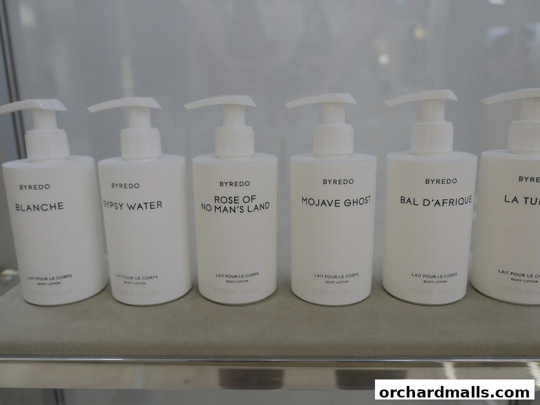 A row of Byredo body lotions with different scent names displayed.