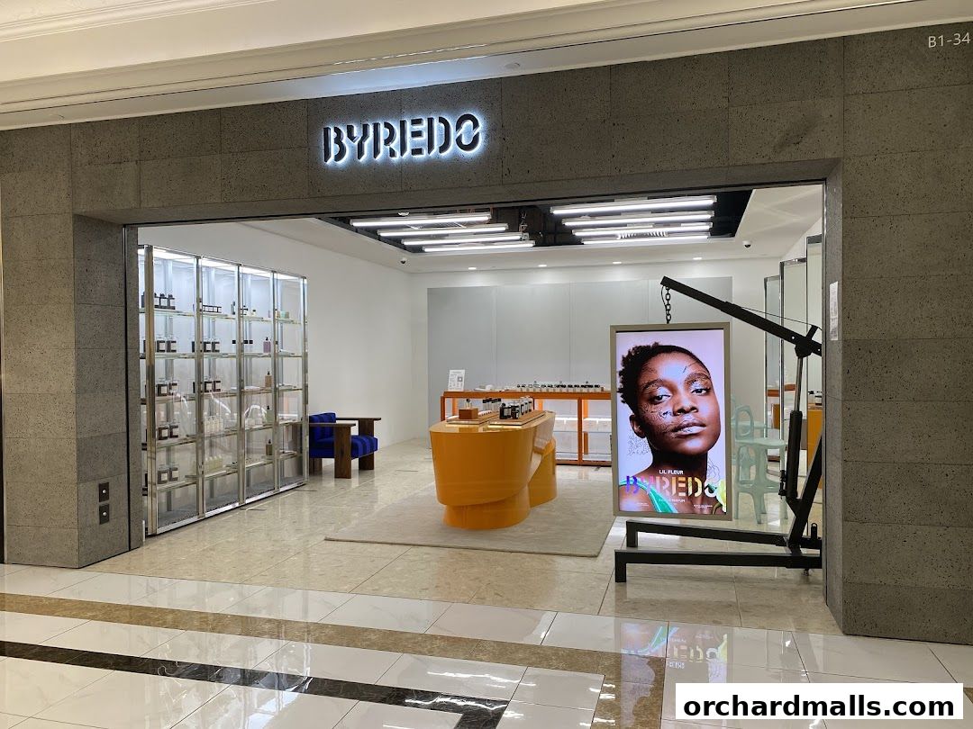 The entrance of a Byredo shop featuring illuminated signage and product displays.