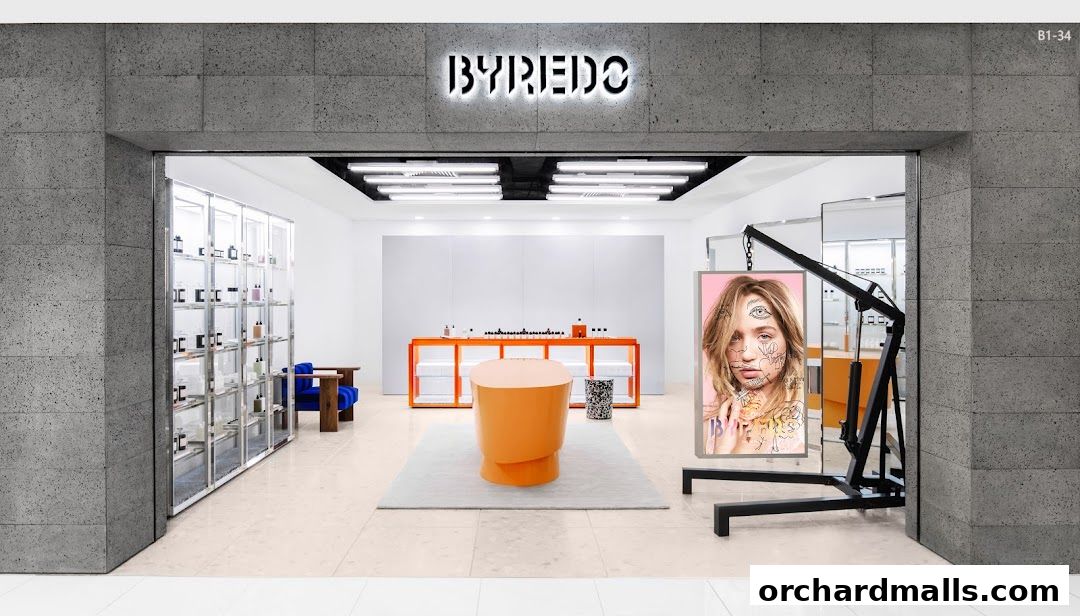 The entrance of a Byredo shop featuring a modern display of perfumes and a striking advertisement.