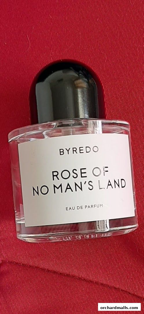 A bottle of Byredo Rose of No Man's Land Eau de Parfum on a red textured surface.