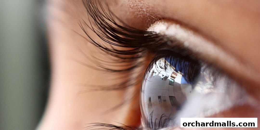 Extreme close-up of a human eye with reflections of buildings in the pupil.