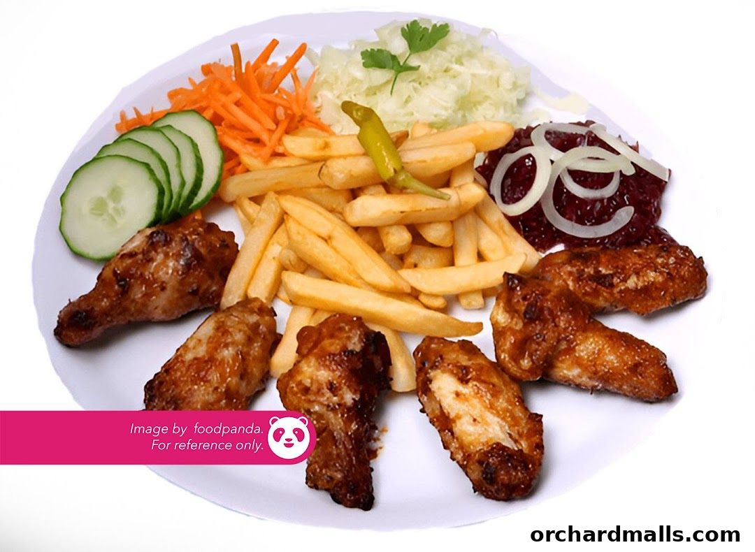 A plate of crispy chicken wings with french fries, coleslaw, shredded carrots, and cucumber slices.
