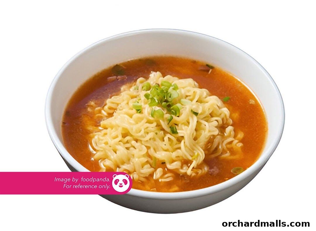 A bowl of instant ramen noodles in broth, garnished with chopped green onions.
