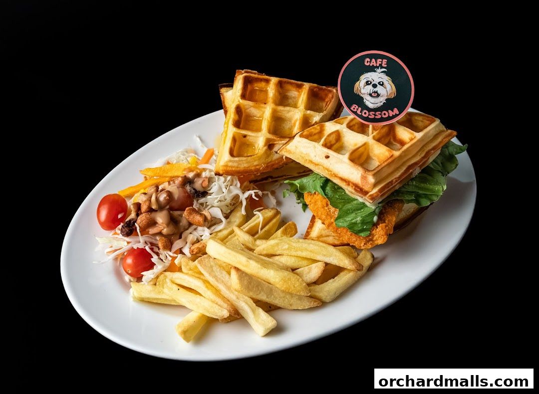 A delicious waffle sandwich with fries and salad on a white plate.