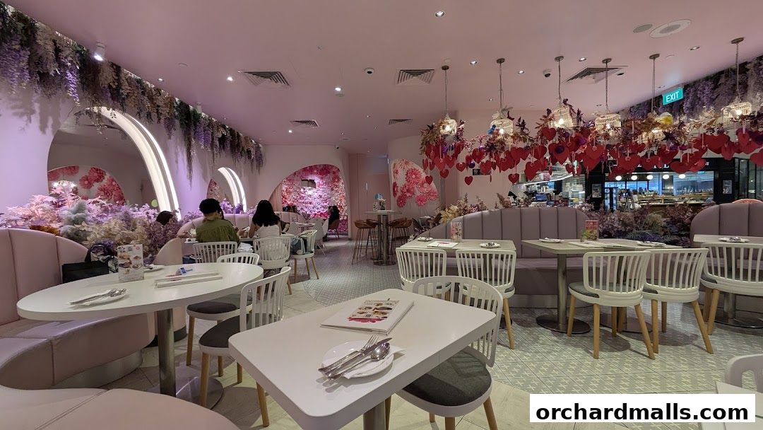 Interior of a beautifully decorated cafe with pink and purple floral accents and heart-shaped decorations.