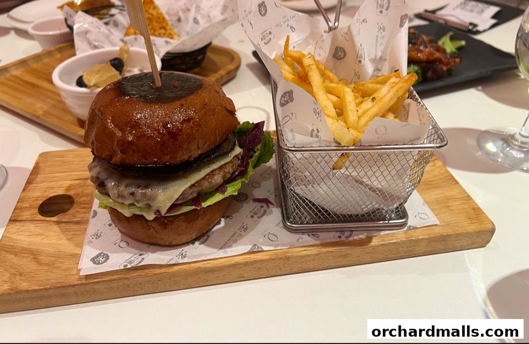 A gourmet burger and fries served on a wooden board at cafe Q classified.