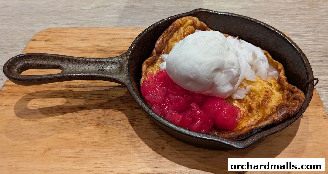 A delicious dessert served in a cast iron pan with ice cream and fruit.
