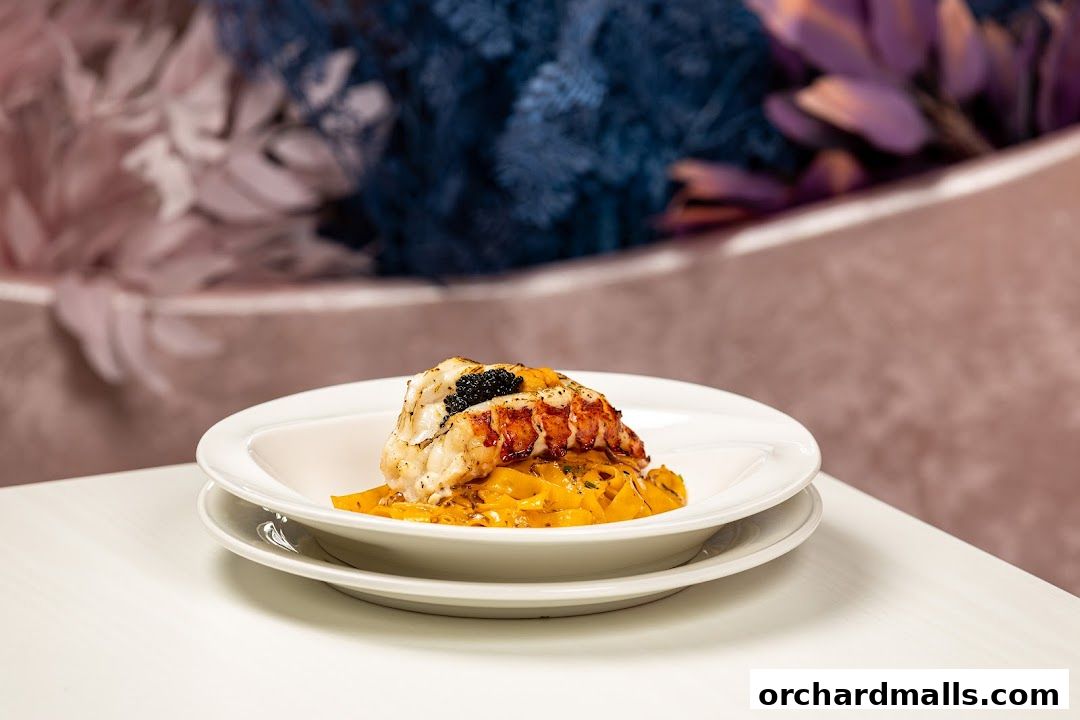 A gourmet dish of lobster tail with caviar served over pasta.