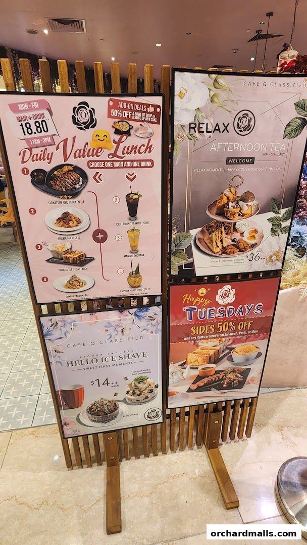 A display board showcasing lunch, afternoon tea, ice shave, and Tuesday specials from Cafe Q Classified.