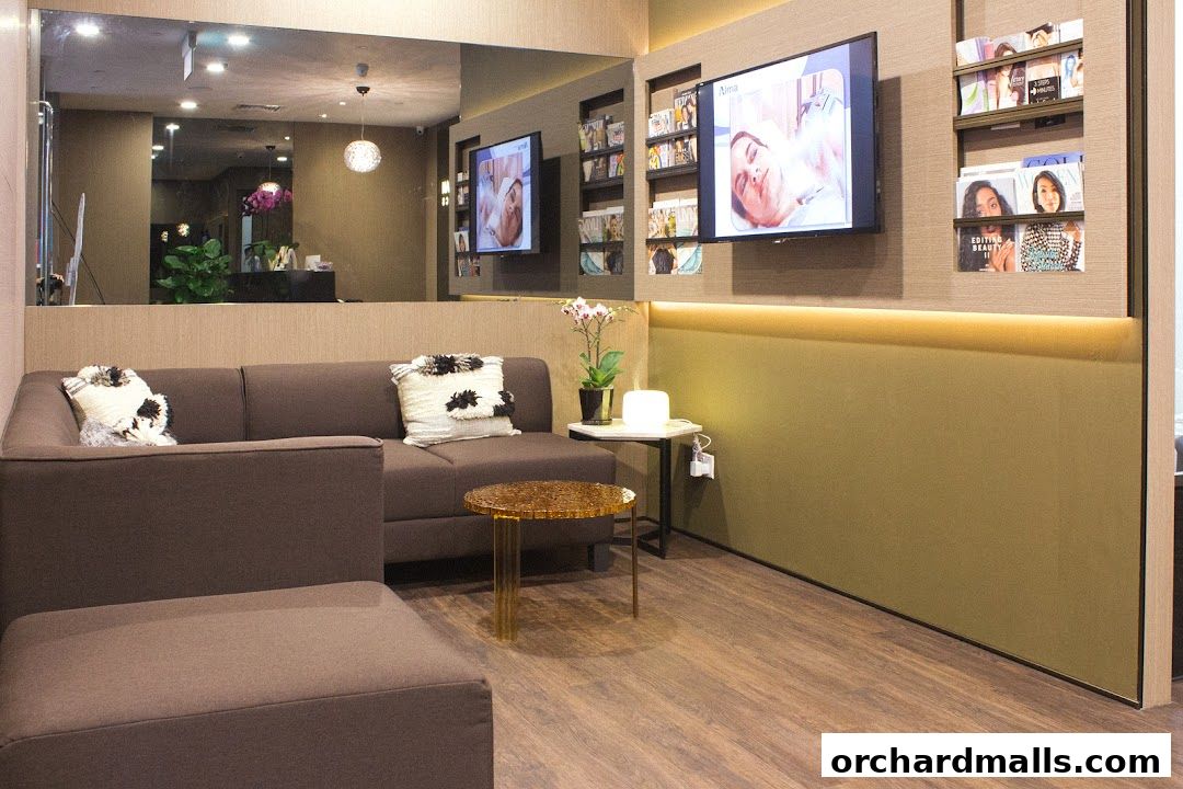 A modern waiting area with a comfortable sofa, coffee table, and screens displaying beauty treatments.