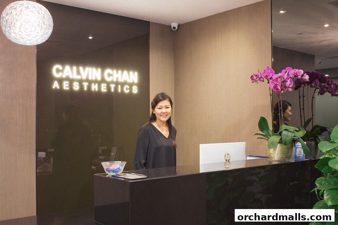 A woman stands behind a reception desk at Calvin Chan Aesthetics.