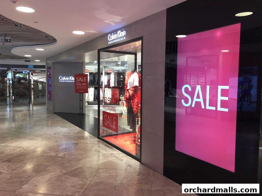 Calvin Klein Performance store entrance with sale signs and mannequins displaying apparel.