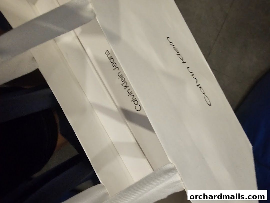 White shopping bags with Calvin Klein and Calvin Klein Jeans logos.