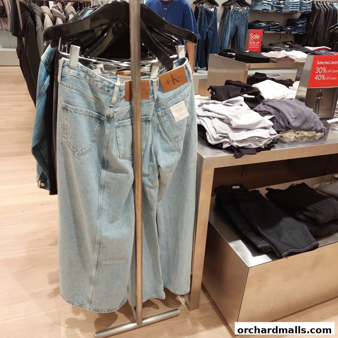 Calvin Klein store interior featuring a display of jeans and folded apparel.