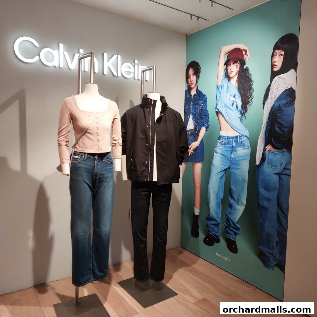 Calvin Klein store display featuring mannequins in denim outfits and a large promotional poster.