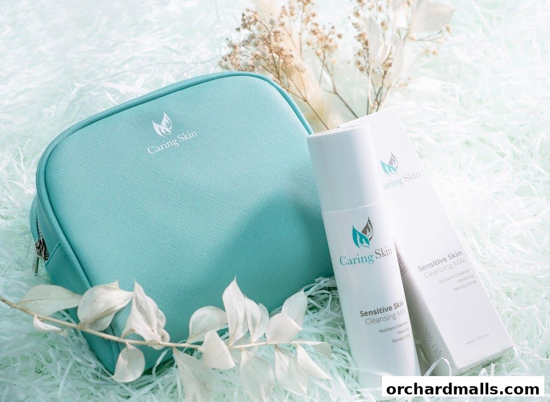 A teal cosmetic bag and a bottle of Sensitive Skin Cleansing Milk by Caring Skin.