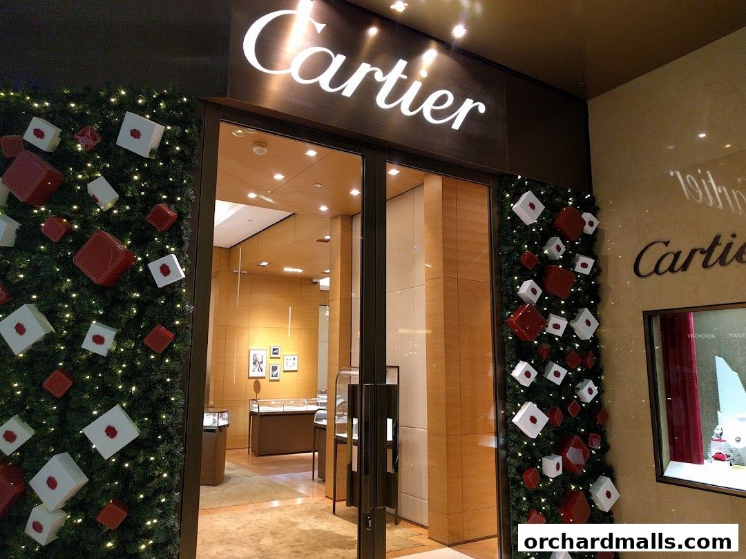 Cartier store entrance decorated with festive greenery and gift boxes.