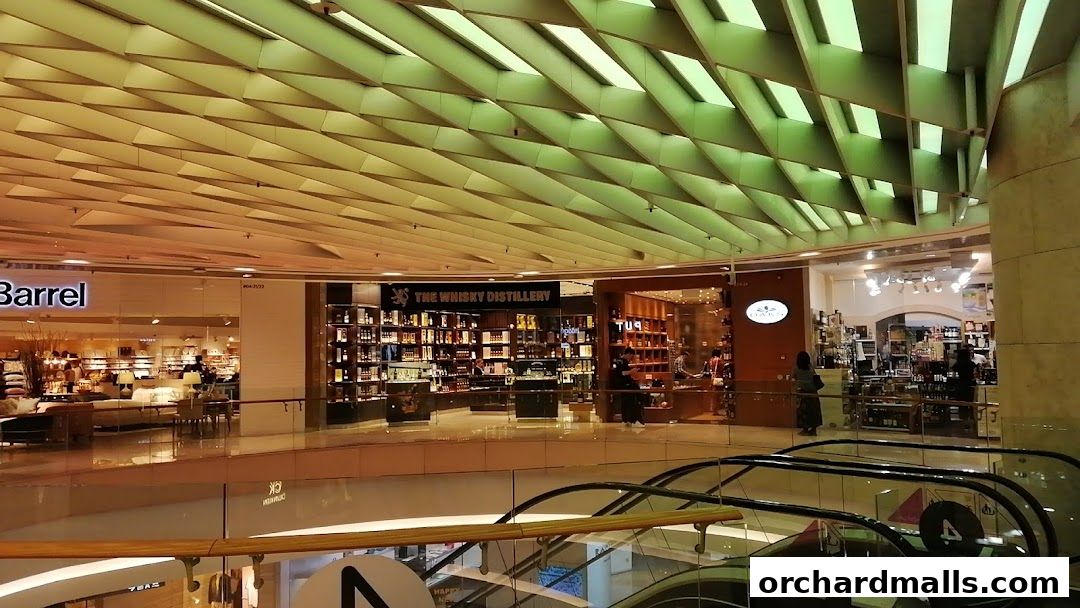 Interior view of a shopping mall with several stores, including a whisky store and a home goods store.