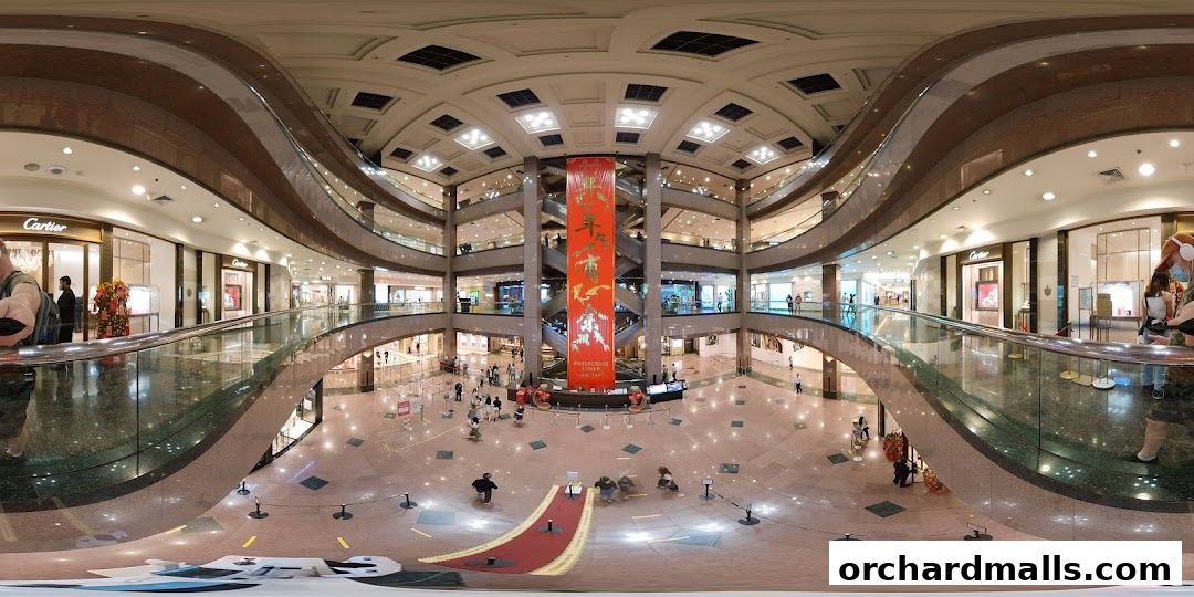 Interior view of a multi-level shopping mall with Cartier stores visible.