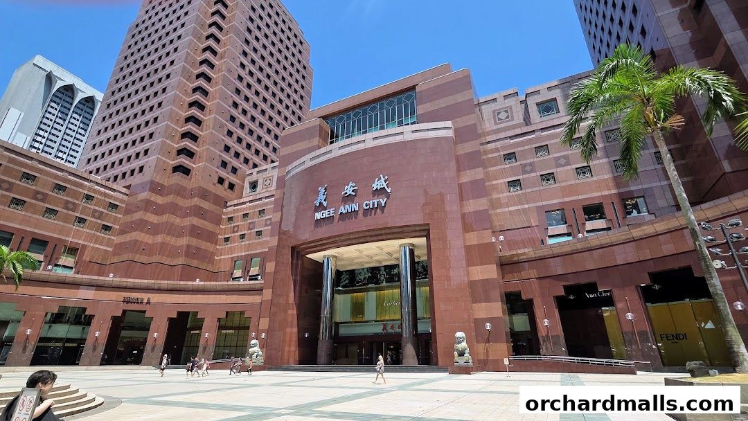 Exterior view of Ngee Ann City mall with Cartier and other luxury brand storefronts visible.