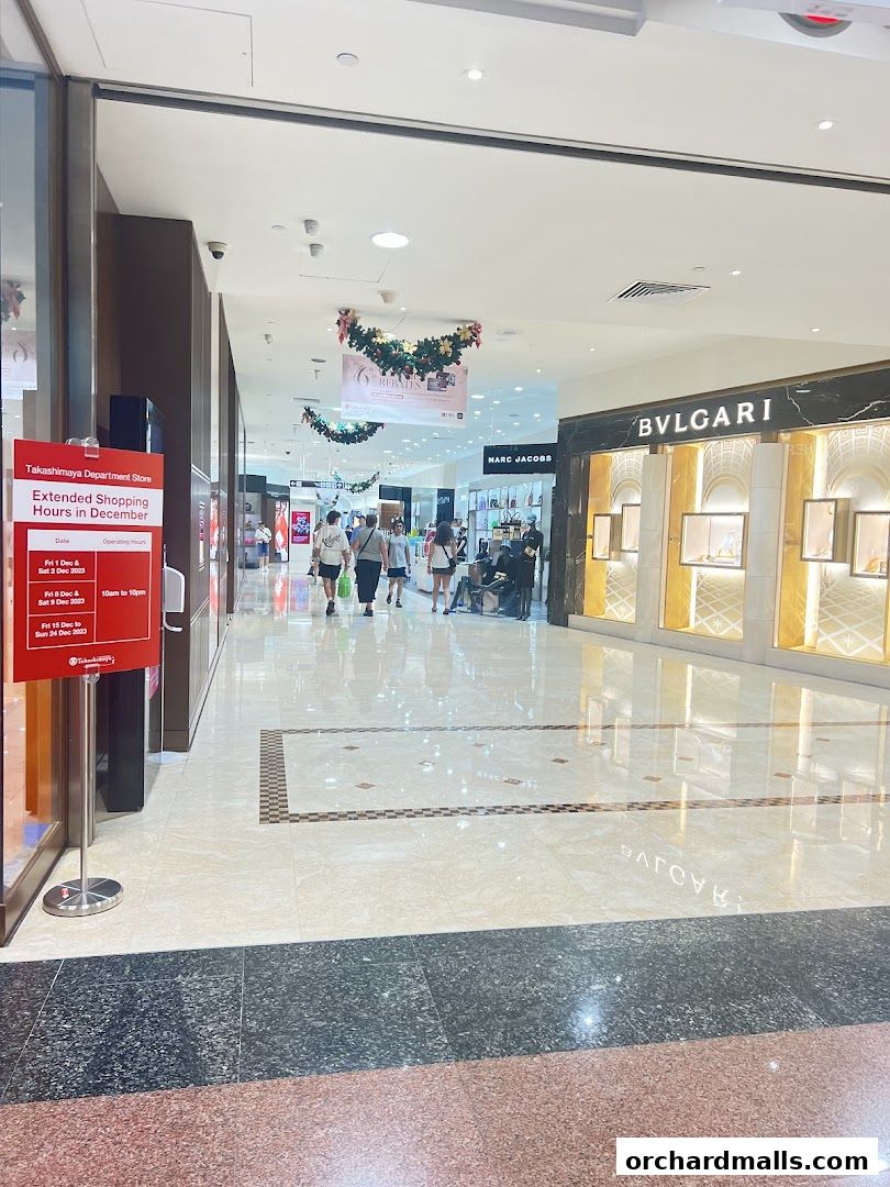 A shopping mall corridor with luxury stores like Bvlgari and Marc Jacobs.