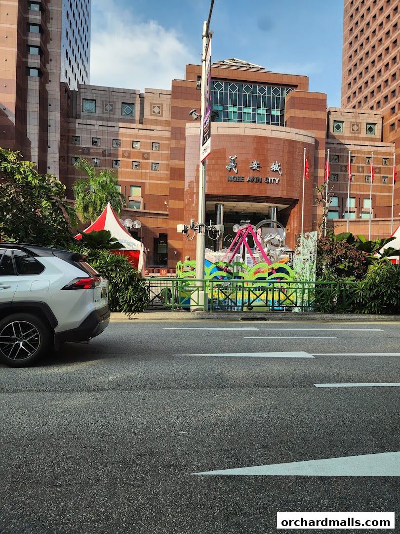 Exterior view of Ngee Ann City mall with a car in the foreground.