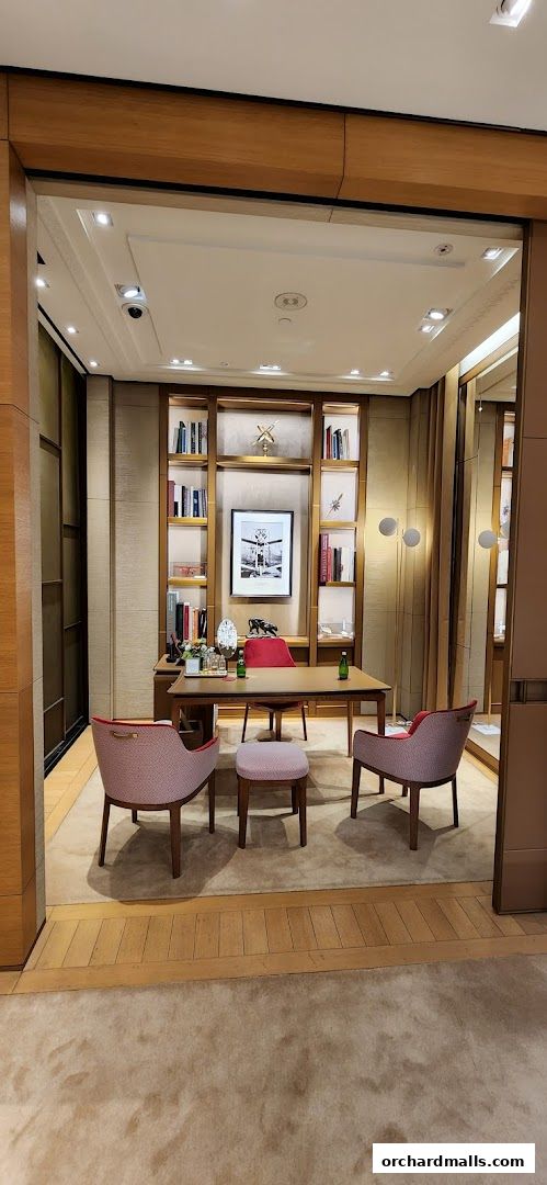 A luxurious Cartier boutique interior with a desk, chairs, and display shelves.