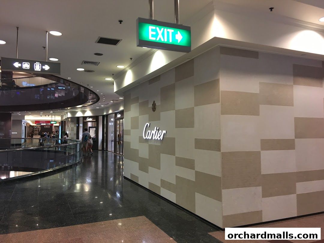The Cartier store entrance in a modern shopping mall with an exit sign above.