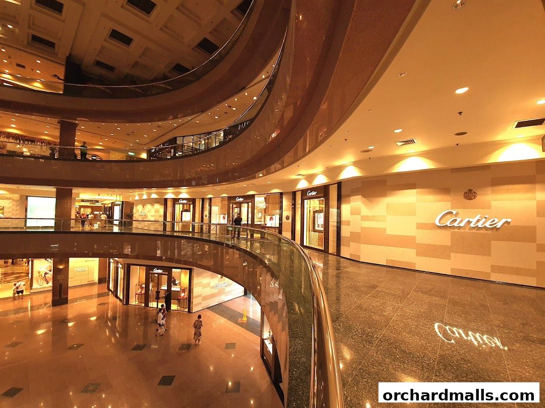 Interior view of a luxury shopping mall with Cartier stores visible on multiple levels.