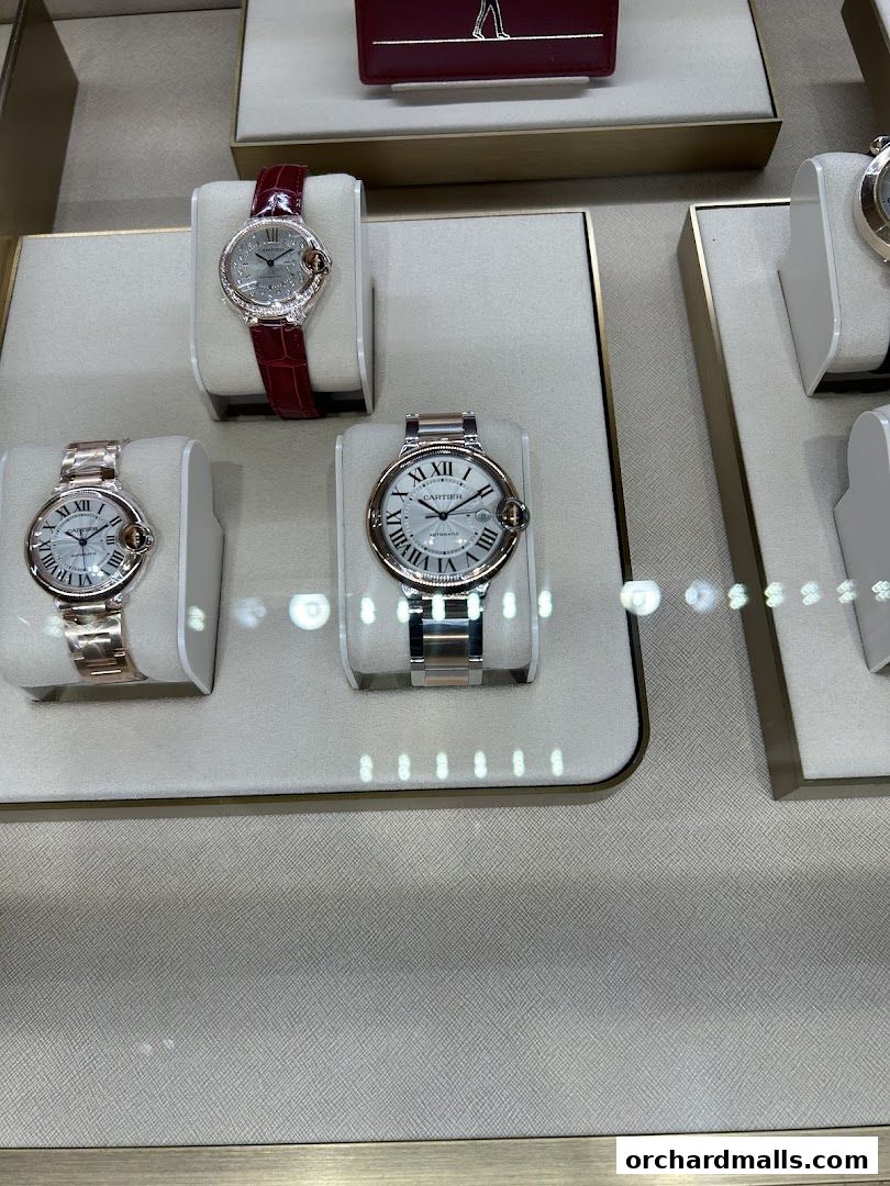 A display of elegant Cartier watches with Roman numerals on their faces.